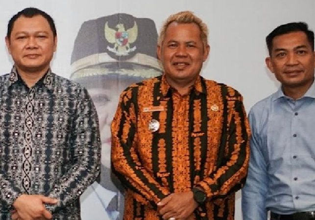 Ketua Apdesi Kabupaten Paser Nasri (tengah) foto bersama dengan Bupati Fahmi Fadli. (Istimewa)